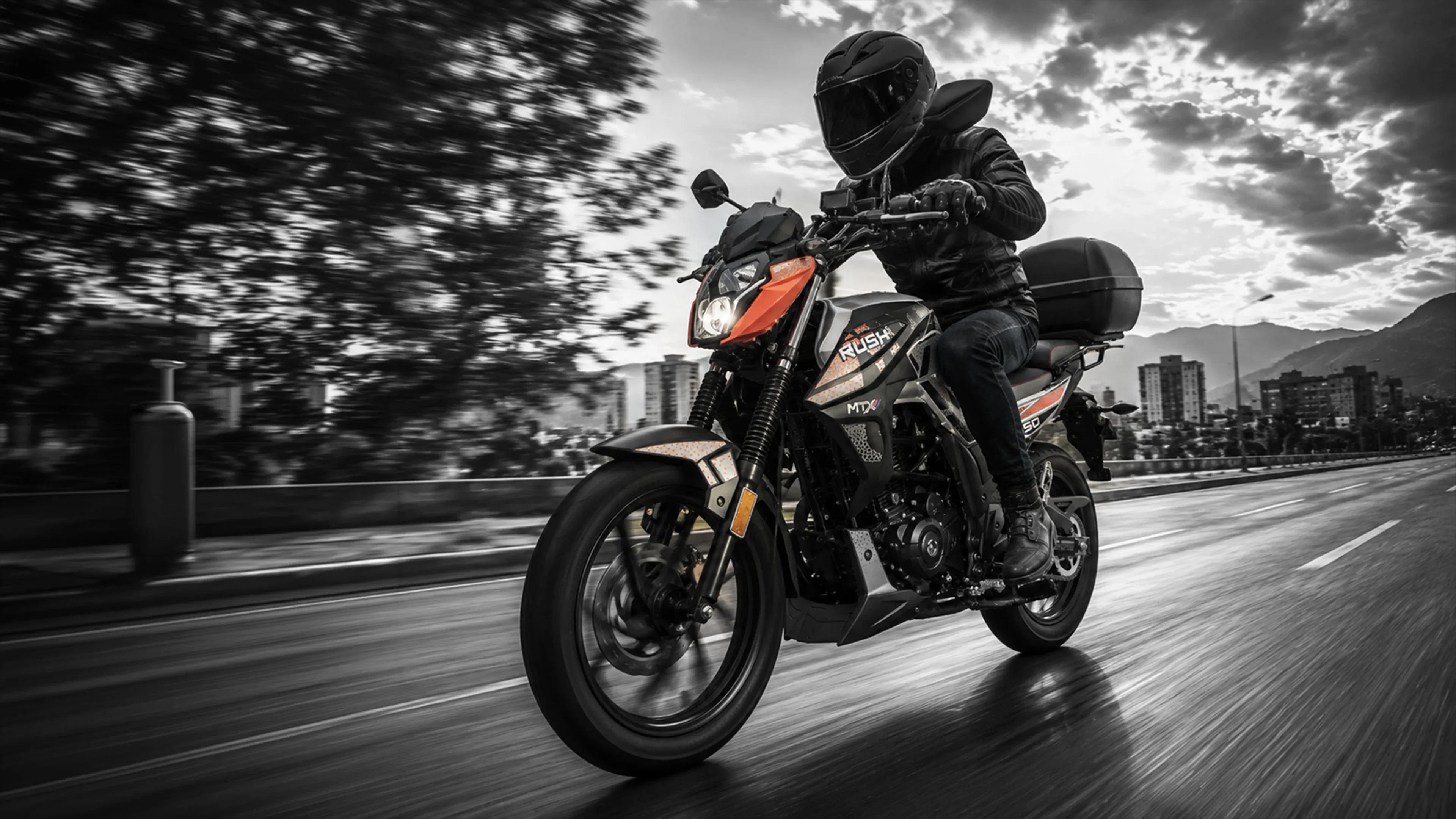Piloto en una MTX Rush 150 por una avenida
